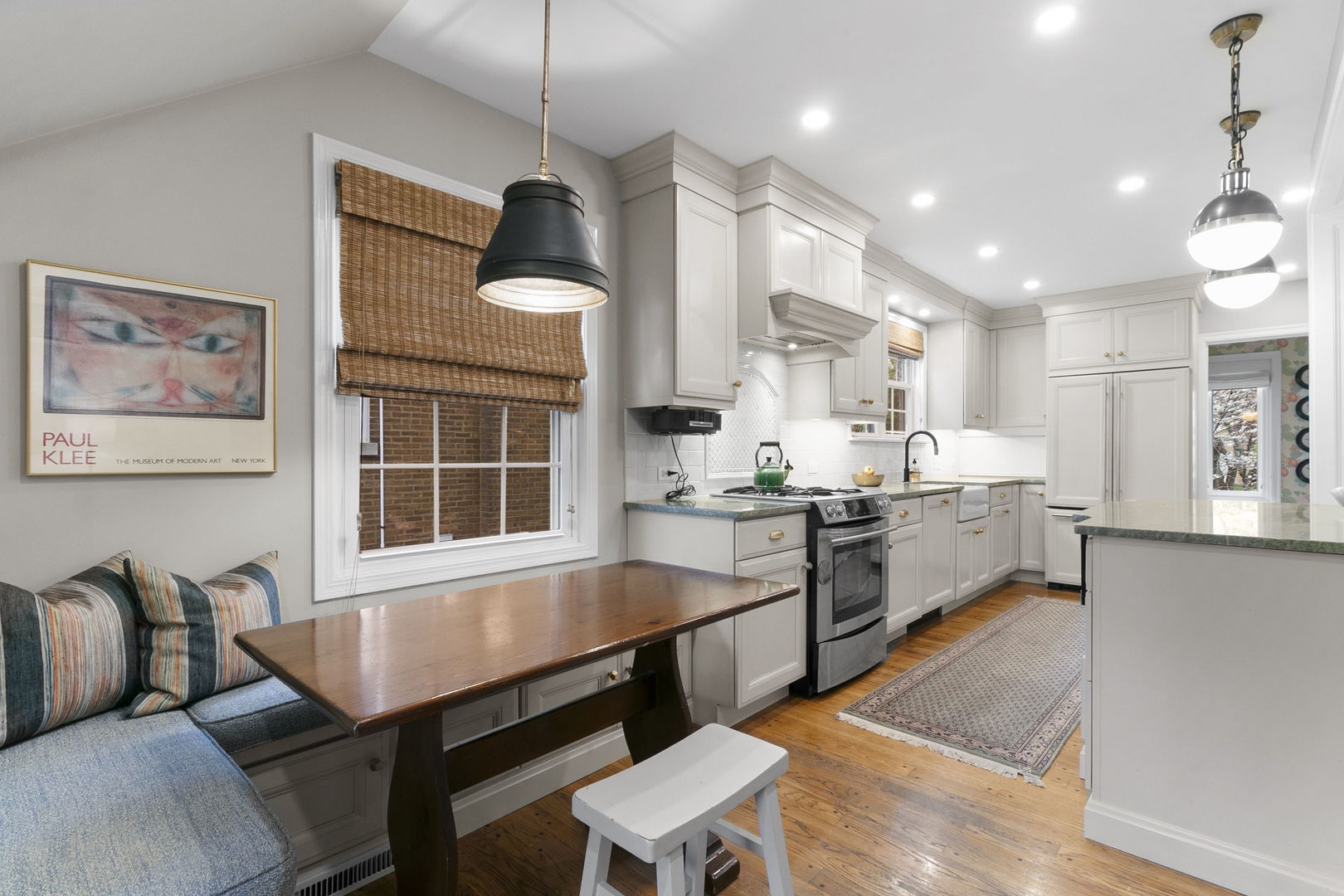 478 Uvedale Road Riverside, IL 60546 - Photo 9 of 40 a kitchen with stainless steel appliances granite countertop a stove top oven a sink dishwasher a dining table and chairs with wooden floor