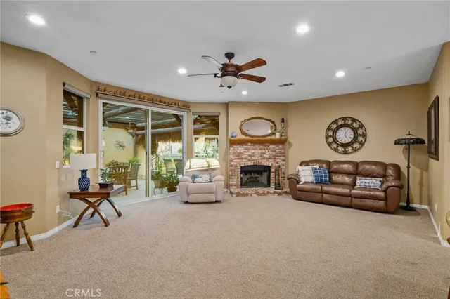 a living room with furniture a fireplace and a large window