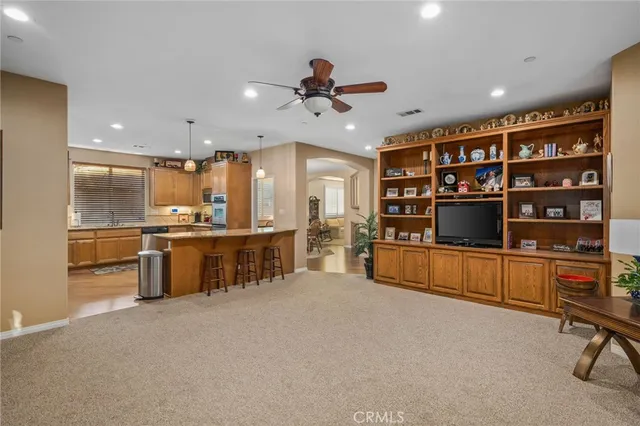a large kitchen with stainless steel appliances kitchen island granite countertop a refrigerator and a sink