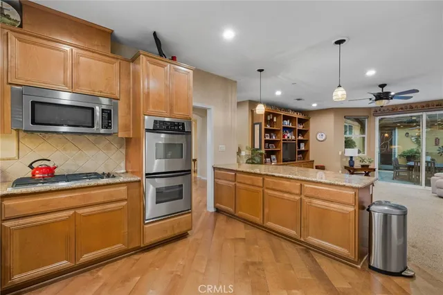 a kitchen with granite countertop a sink stainless steel appliances and cabinets