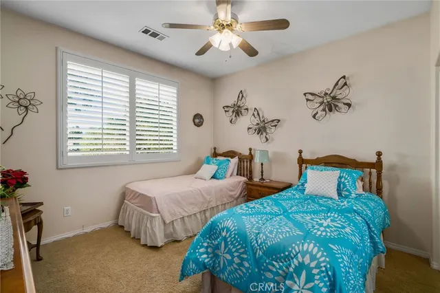 a bedroom with two beds and a chandelier