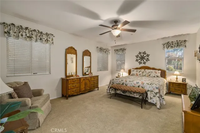 a spacious bedroom with a bed a couch and dresser