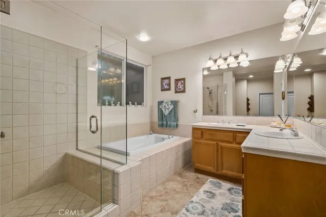 a spacious bathroom with a sink a toilet a mirror and shower