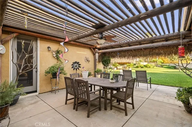 a view of a dinning table and chairs in patio in front of a house