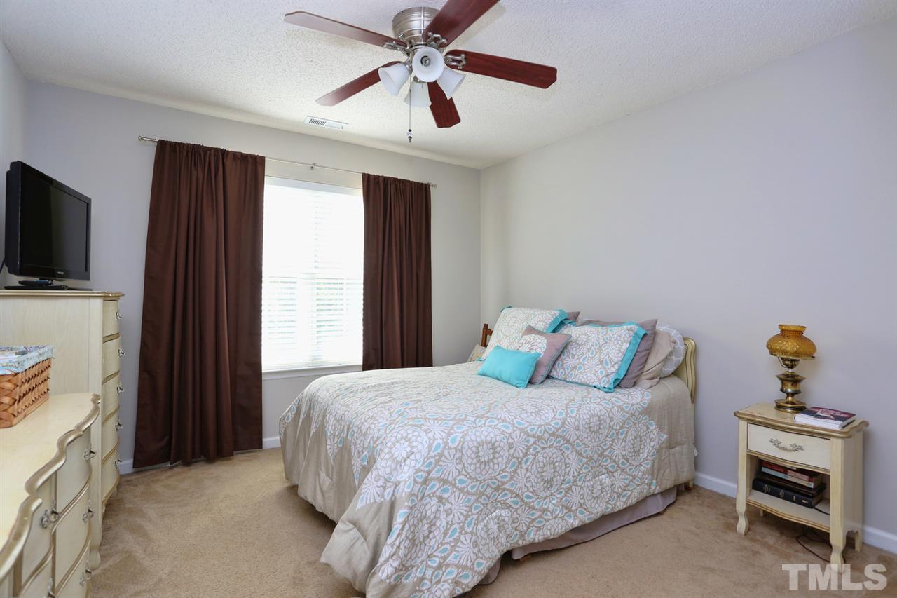 5033 Gable Ridge Drive Durham, NC 27713 - Photo 11 of 25 a bedroom with a bed and a flat tv screen on dresser
