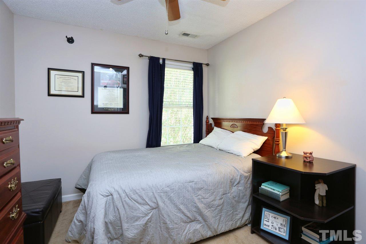 5033 Gable Ridge Drive Durham, NC 27713 - Photo 13 of 25 a bedroom with a bed and a lamp on table