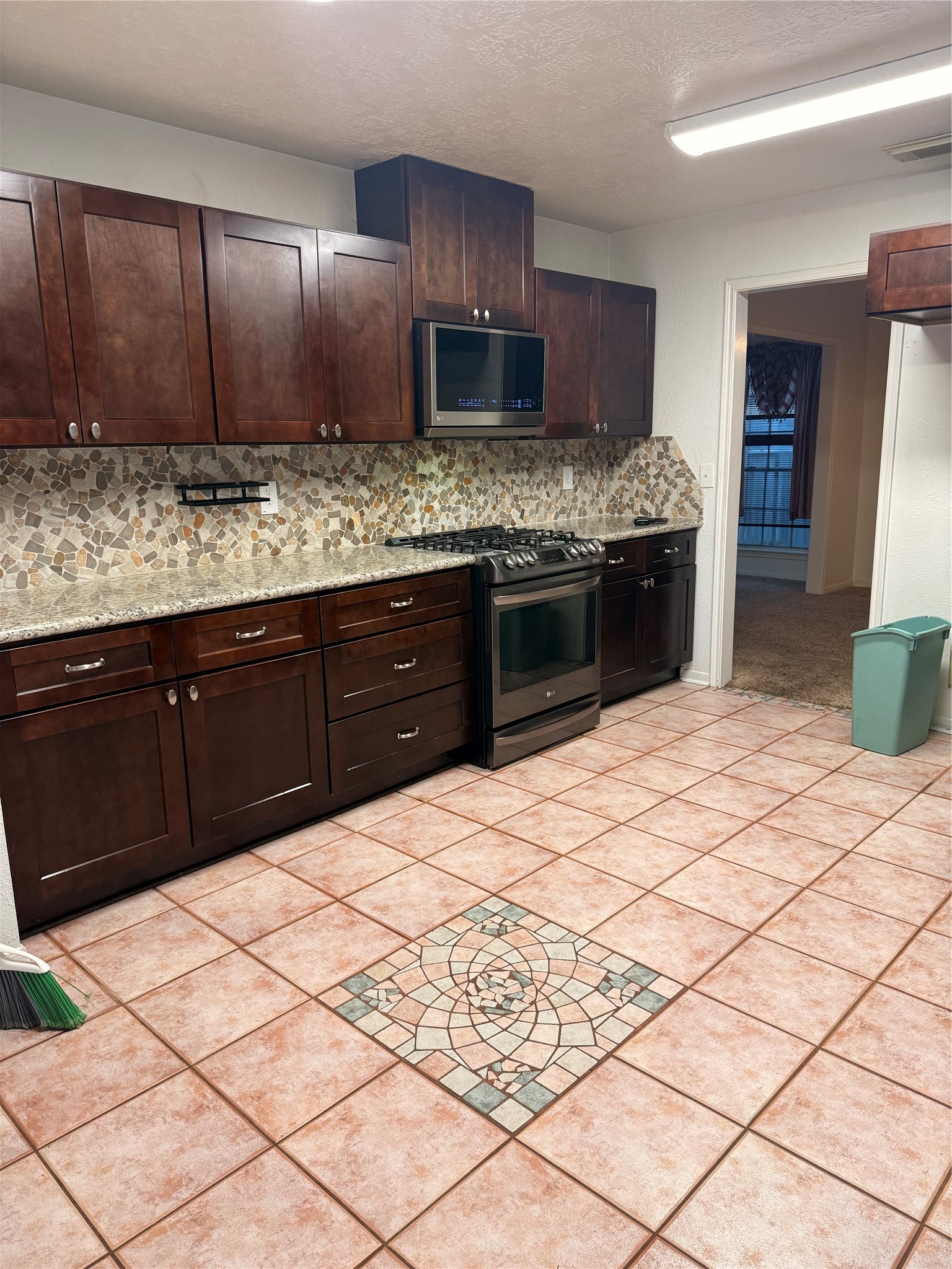 5619 Roserock Lane Spring, TX 77379 - Photo 6 of 14 a kitchen with stainless steel appliances kitchen island granite countertop a sink stove and refrigerator
