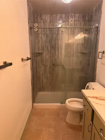 a bathroom with a shower a toilet and a sink