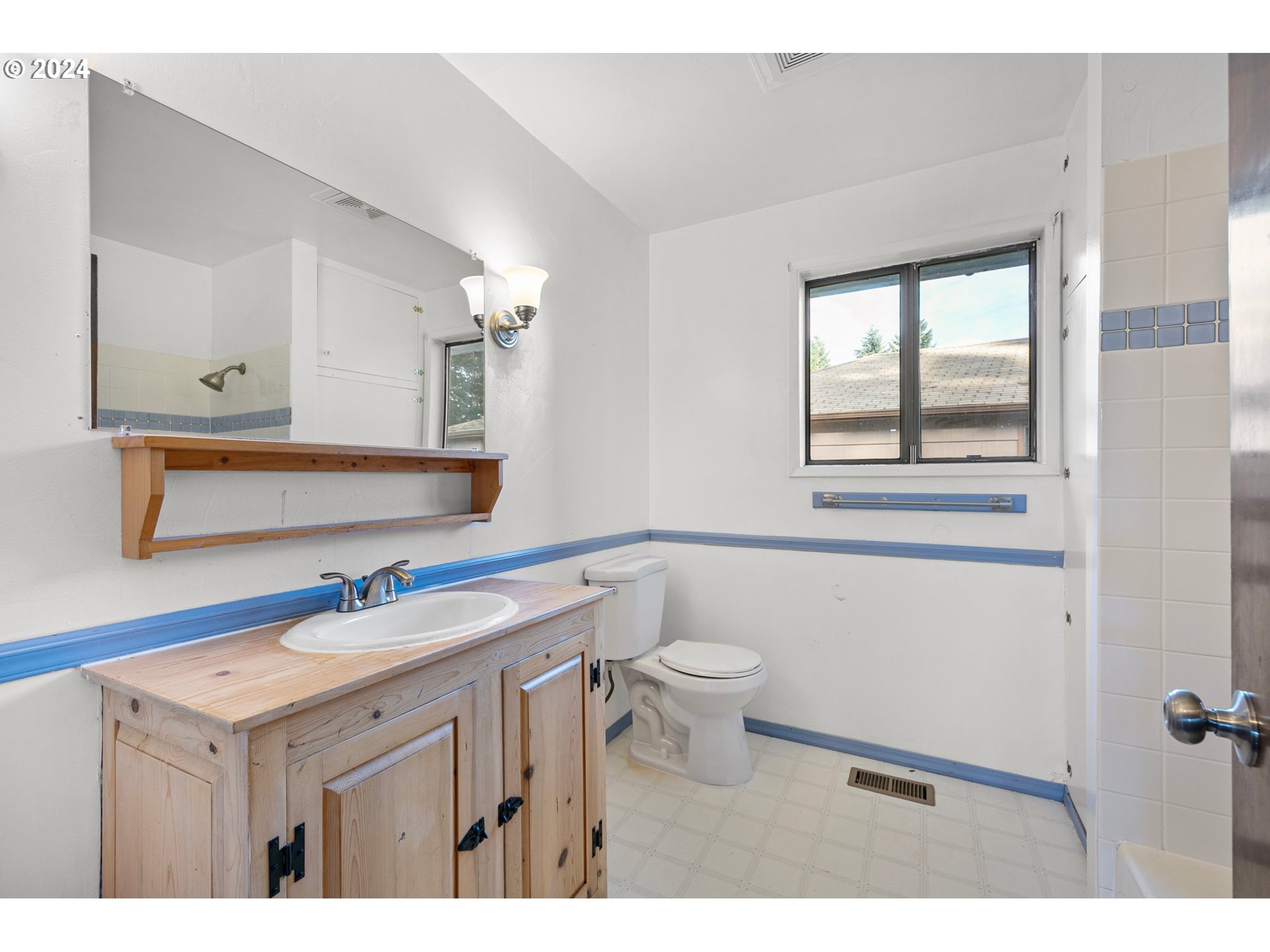 4091 Bell Avenue Eugene, OR 97402 - Photo 12 of 29 a bathroom with a sink a toilet a mirror and a window
