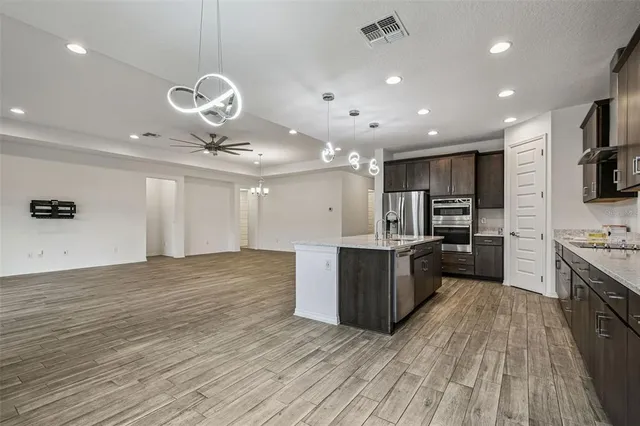a large kitchen with stainless steel appliances granite countertop a large center island and a stove
