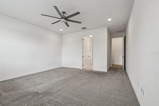 an empty room with closet and windows