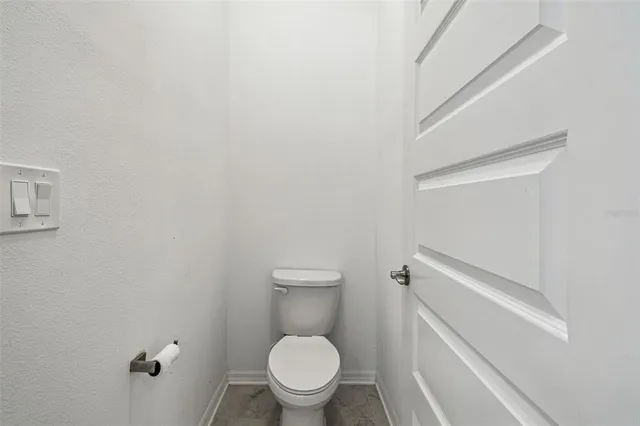 a white toilet sitting in a bathroom next to a wooden wall