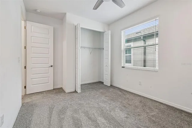 an empty room with closet and windows