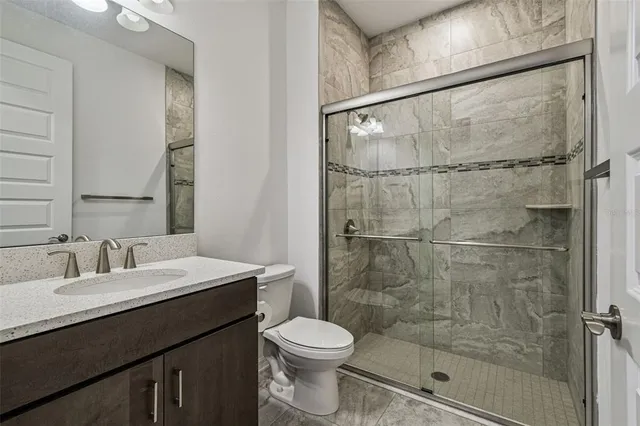 a bathroom with a sink toilet and shower