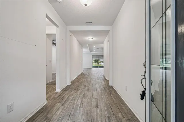 a view of a hallway with wooden floor and staircase