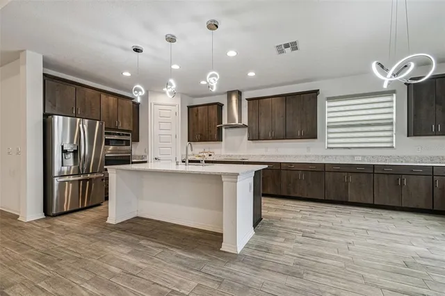 a kitchen with stainless steel appliances a refrigerator sink and microwave