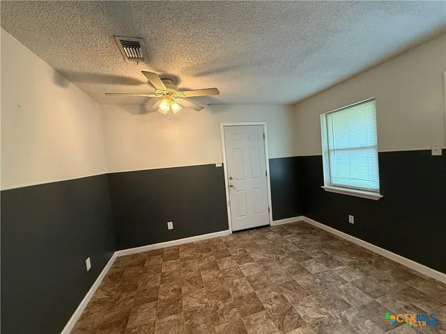a view of a livingroom with a ceiling fan and window