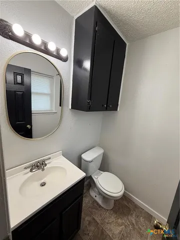 a bathroom with a toilet sink and mirror