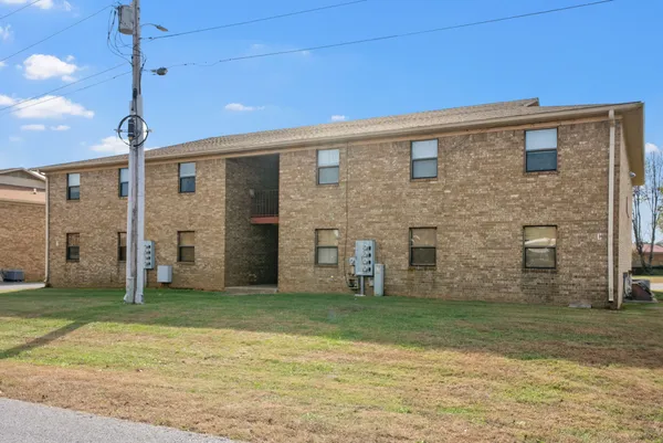 a view of a brick house with a backyard