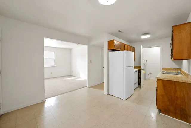 a view of a kitchen with a refrigerator a microwave and a sink