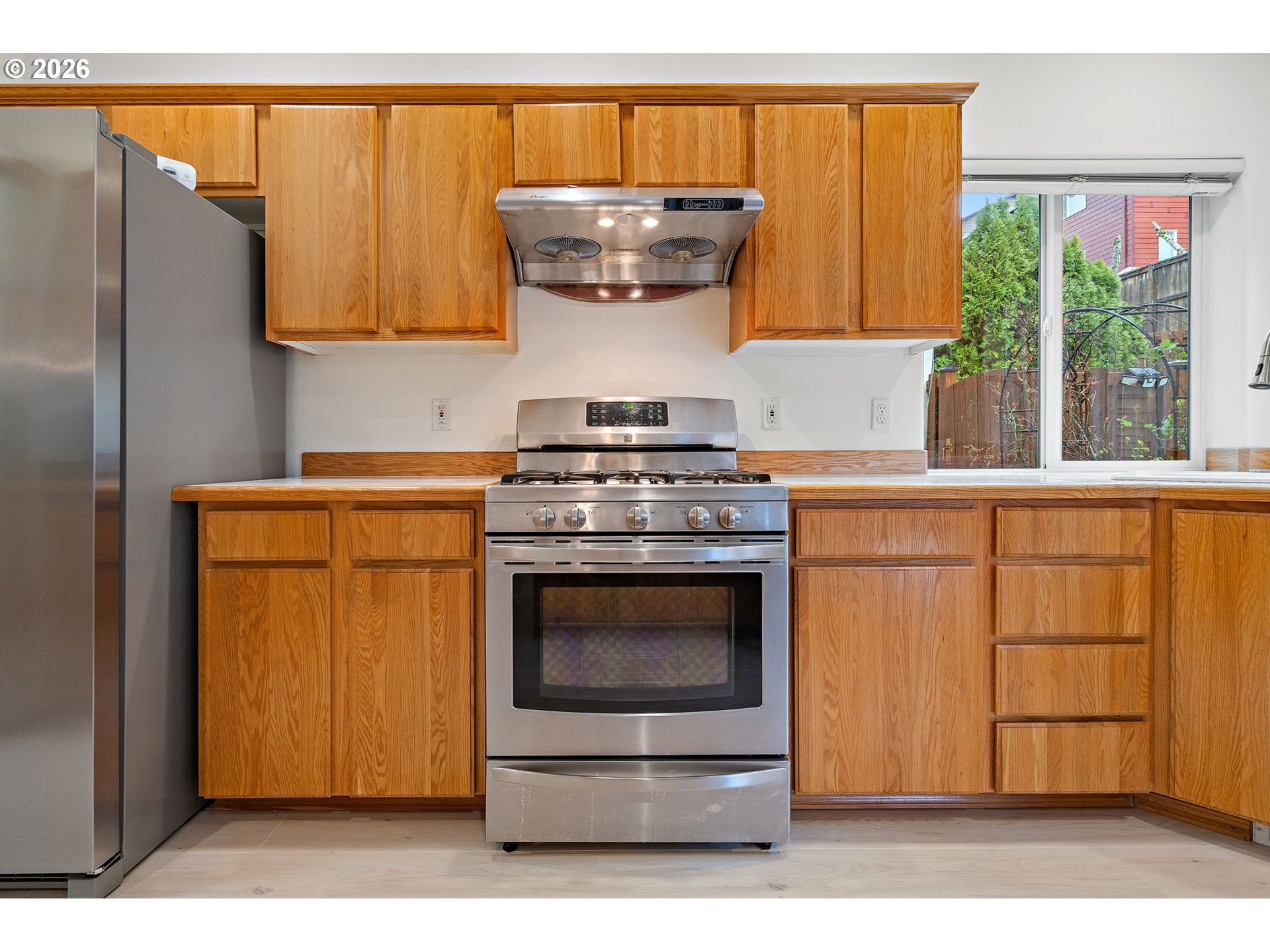 15460 Southwest 145th Terrace Tigard, OR 97224 - Photo 23 of 45 a kitchen with stainless steel appliances wooden cabinets and a sink