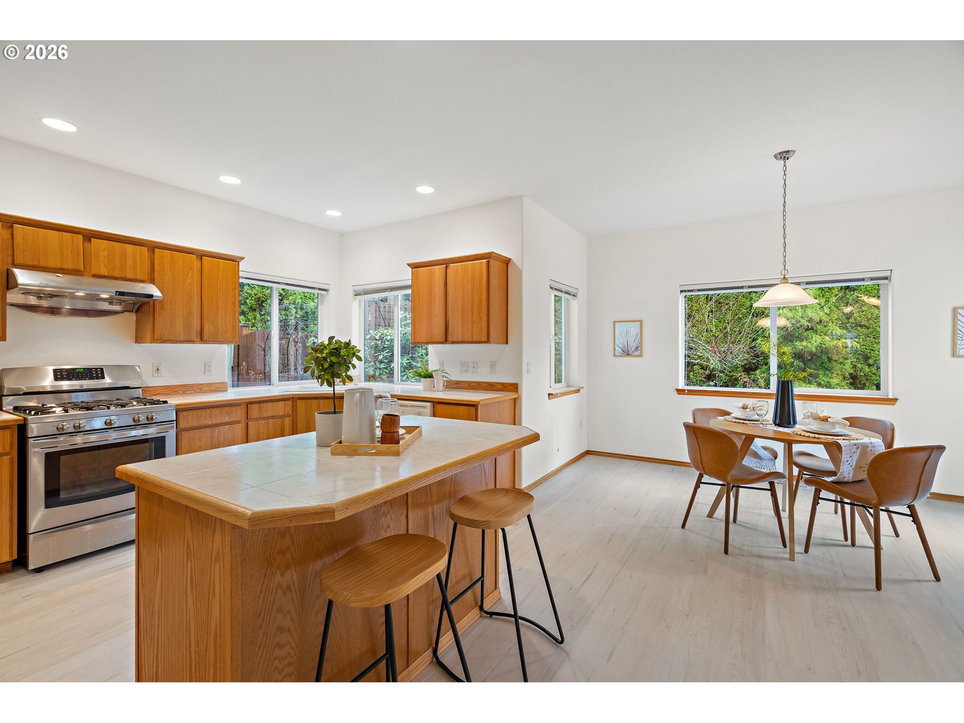 15460 Southwest 145th Terrace Tigard, OR 97224 - Photo 24 of 45 a kitchen with a table chairs a stove a sink a dining table and chairs