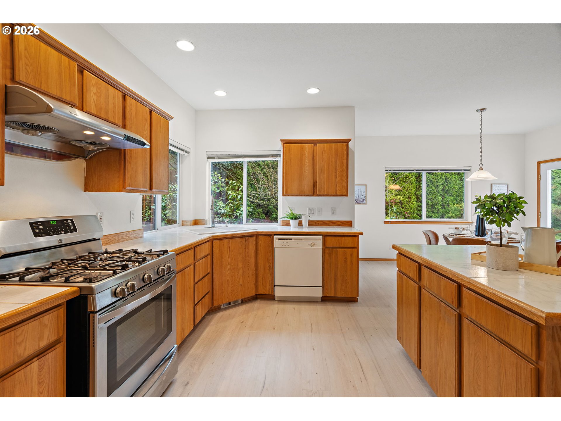 15460 Southwest 145th Terrace Tigard, OR 97224 - Photo 25 of 45 a kitchen with stainless steel appliances kitchen island a large window a sink and cabinets