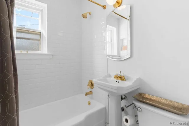 a bathroom with a bathtub sink and a window