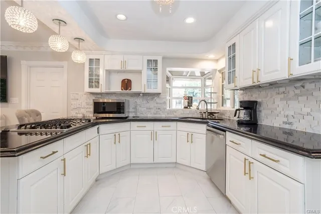 a kitchen with granite countertop white cabinets and white appliances