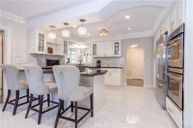 a kitchen with stainless steel appliances kitchen island granite countertop a refrigerator and a stove top oven