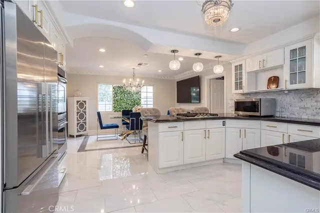 a kitchen with granite countertop a sink cabinets and stainless steel appliances
