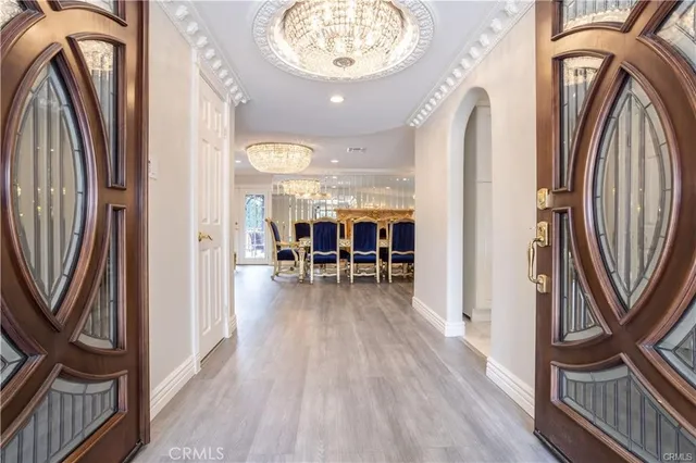 a view of a hallway with wooden floor and a chandelier