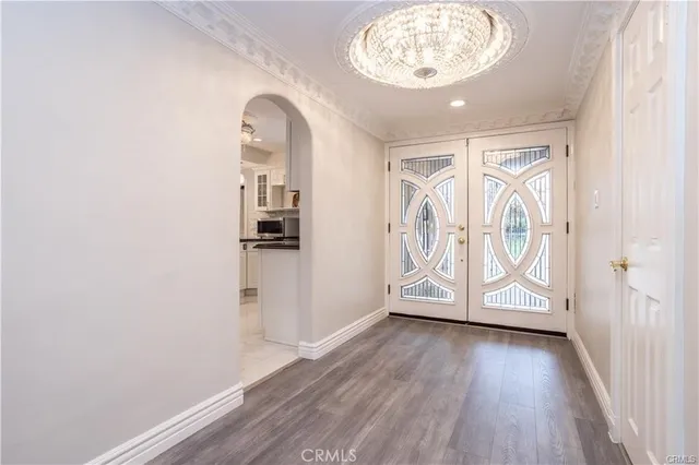 an entryway at a room with wooden floor door and windows