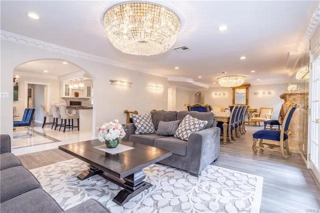 a living room with furniture a table and kitchen view