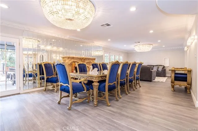 a dining room with wooden floor glass top table and chairs