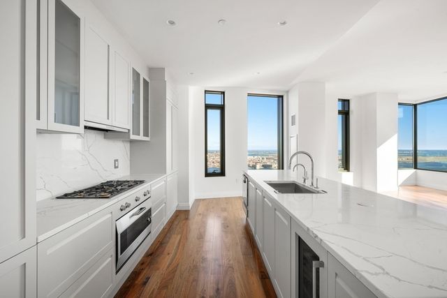 a kitchen with granite countertop a sink stove and cabinets