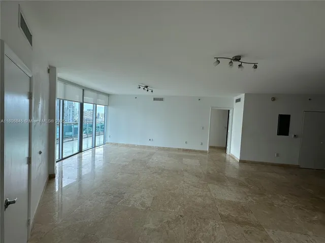 a view of an empty room with kitchen
