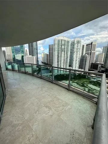 a view of kitchen with refrigerator and white cabinets