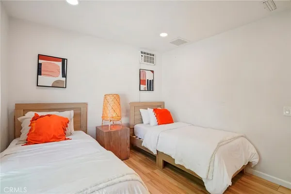 a bedroom with two bed and painting on the wall