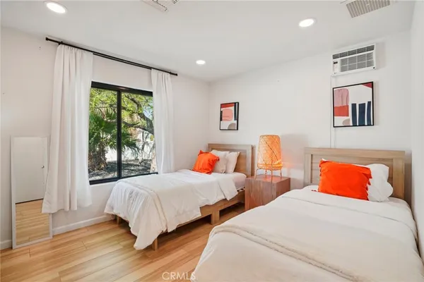 a bedroom with two beds and a large window