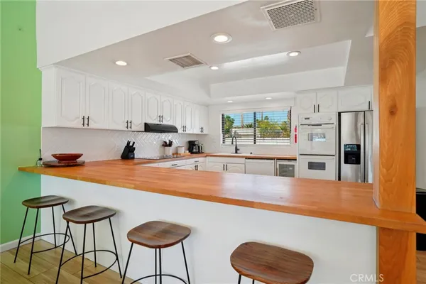 a kitchen with stainless steel appliances granite countertop a sink a stove and a refrigerator