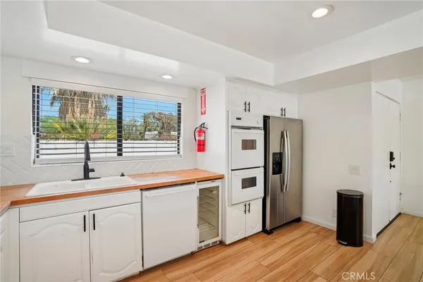 a kitchen with refrigerator cabinets and wooden floor