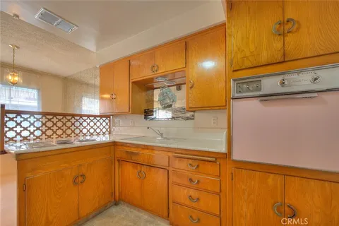 a kitchen with stainless steel appliances granite countertop a sink a stove cabinets and wooden floor