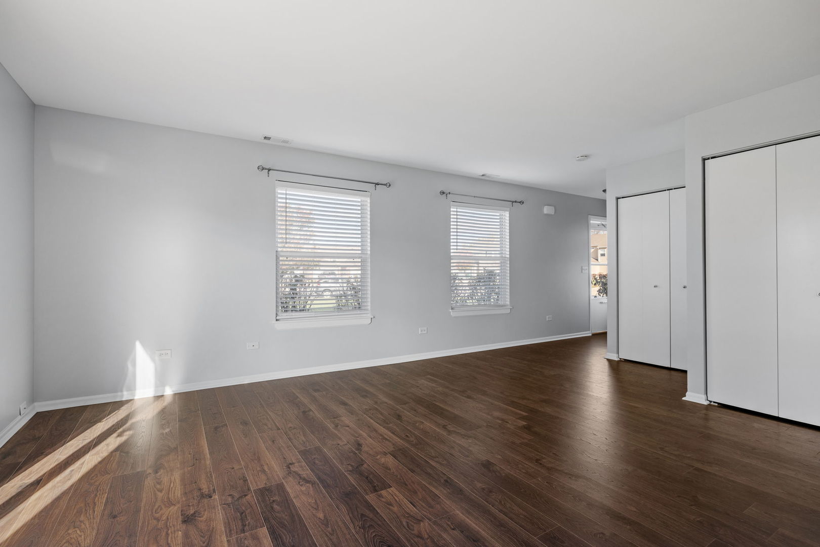 25172 Faraday Road, Unit 1 Manhattan, IL 60442 - Photo 6 of 25 an empty room with wooden floor and windows