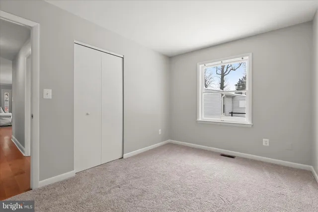 an empty room with windows and closet