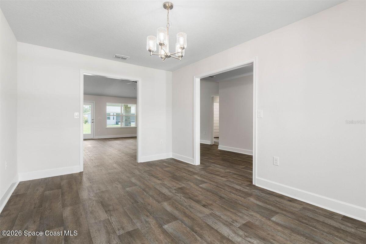 962 Seneca Avenue Sebastian, FL 32958 - Photo 11 of 28 wooden floor in an empty room with a window
