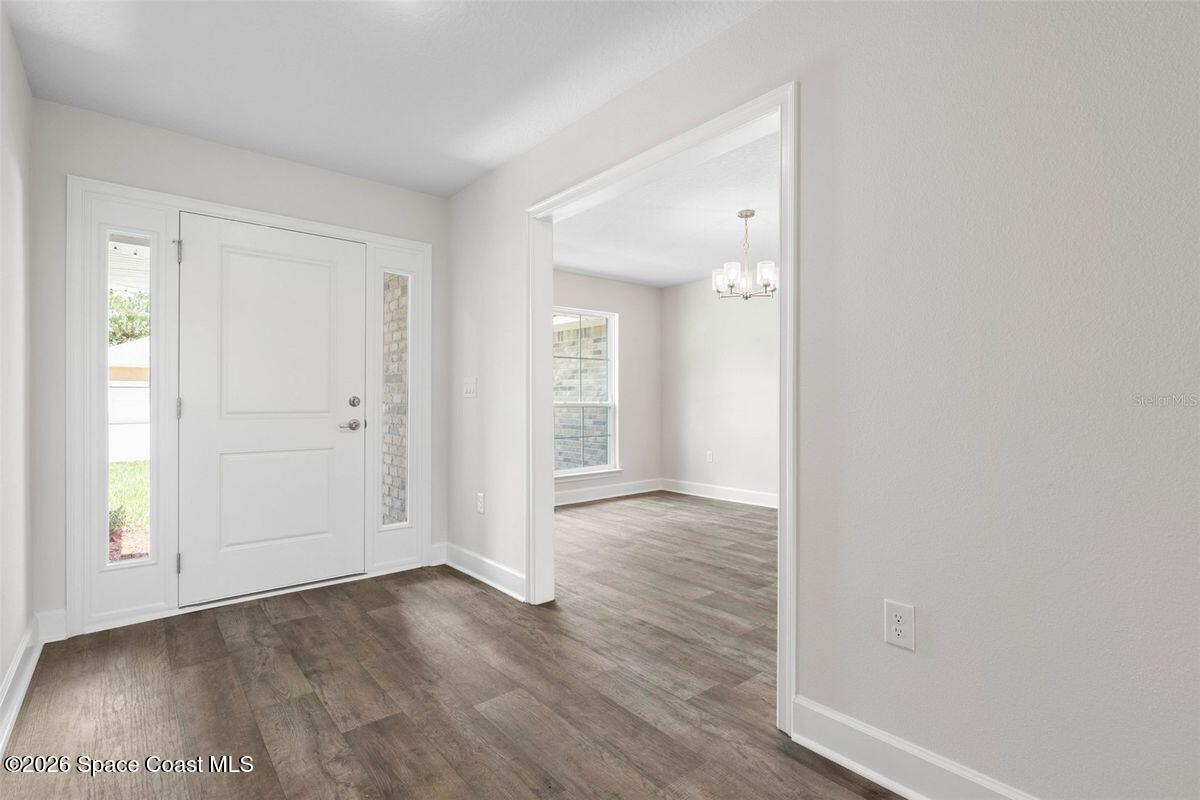 962 Seneca Avenue Sebastian, FL 32958 - Photo 13 of 28 an empty room with wooden floor and windows