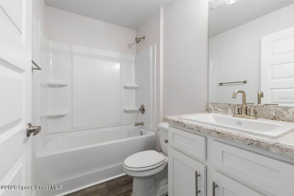 962 Seneca Avenue Sebastian, FL 32958 - Photo 14 of 28 a bathroom with a granite countertop toilet a sink and a bathtub