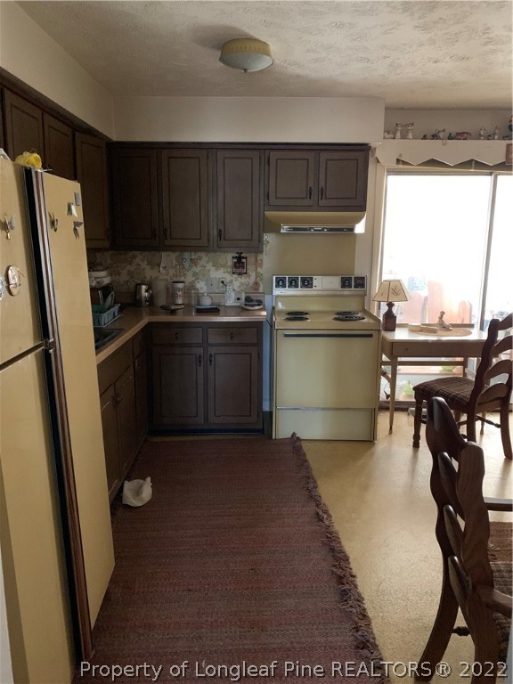 1231 Loop Road Raeford, NC 28376 - Photo 6 of 11 a kitchen with a sink a stove and refrigerator