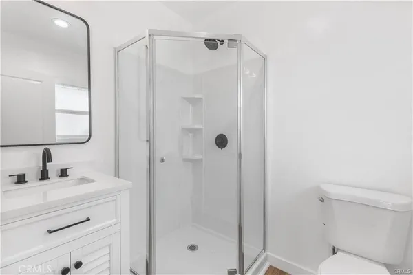 a bathroom with a shower a sink and mirror